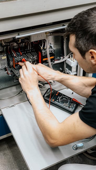 An electrician uses a multimeter to test and diagnose connections in an open electrical panel.